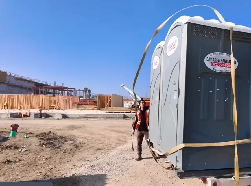 Man unloading porta potty cabins