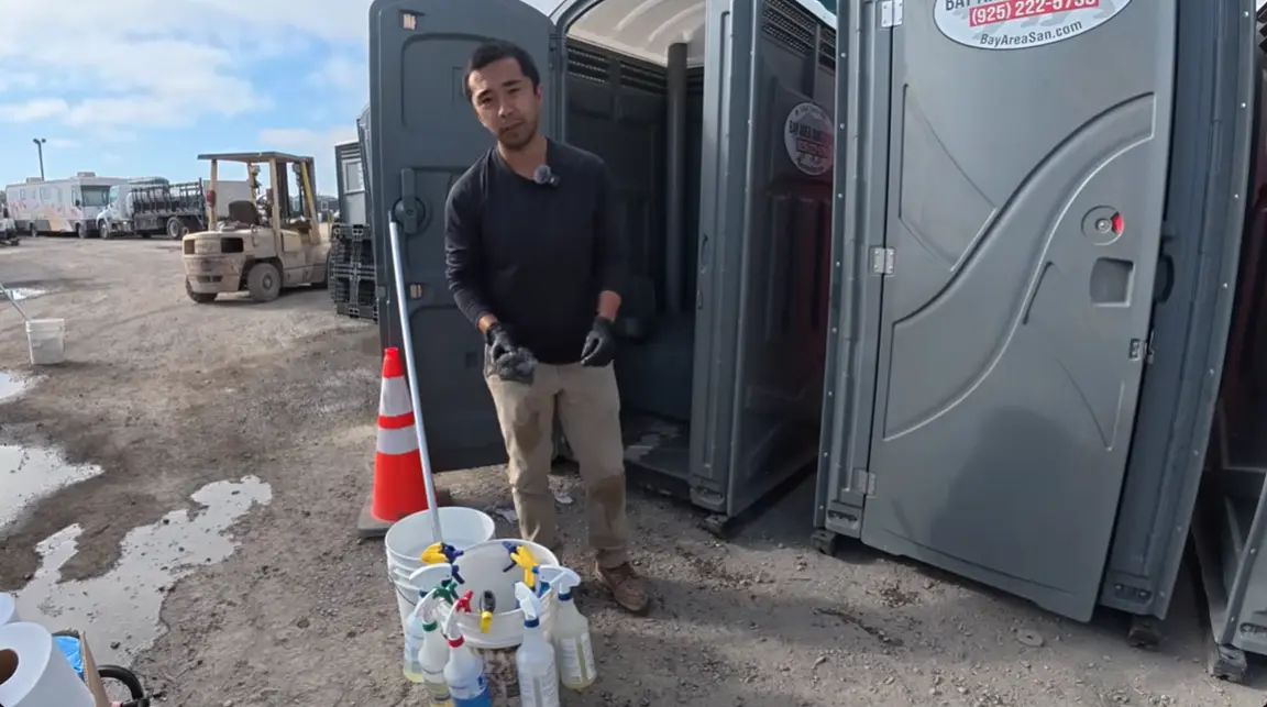 worker sanitizing restroom cabins