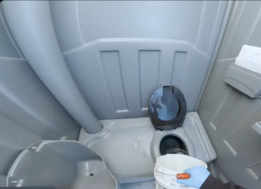 man cleaning potty commode